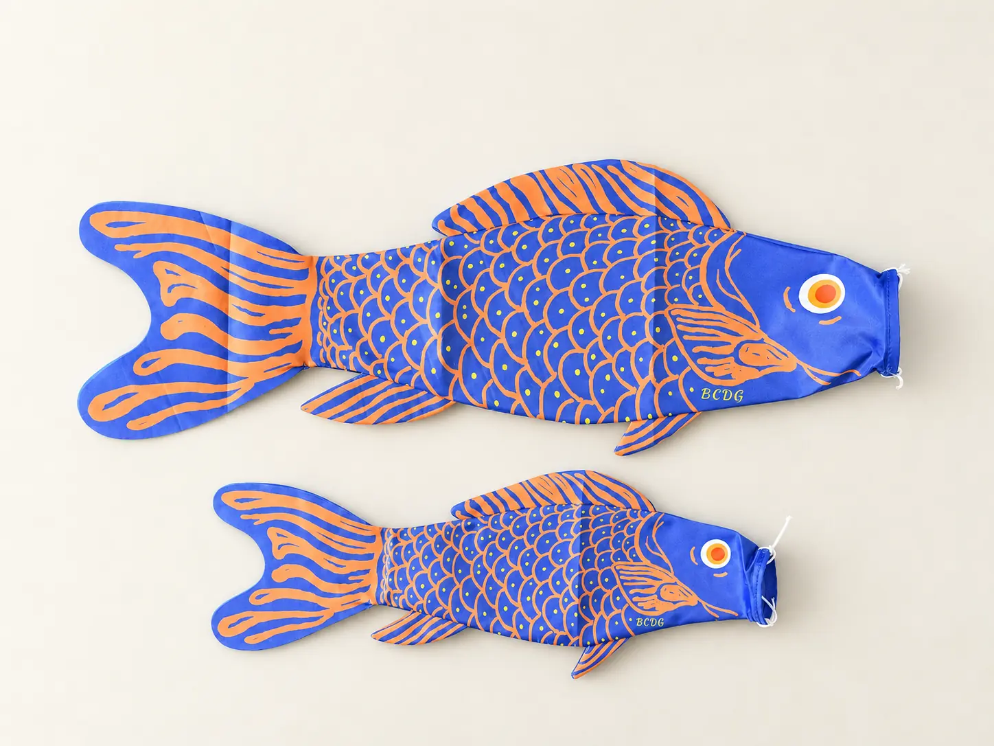 Écailles Bleues et Oranges in 50 and 75 cm, laid flat on an ivory background